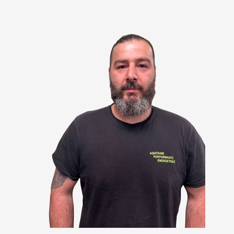 Homme T-shirt Noir Aquitaine Performance Énergétique Homme barbu avec les cheveux tirés en arrière portant un t-shirt noir avec inscription jaune fluo "AQUITAINE PERFORMANCE ENERGETIQUE".